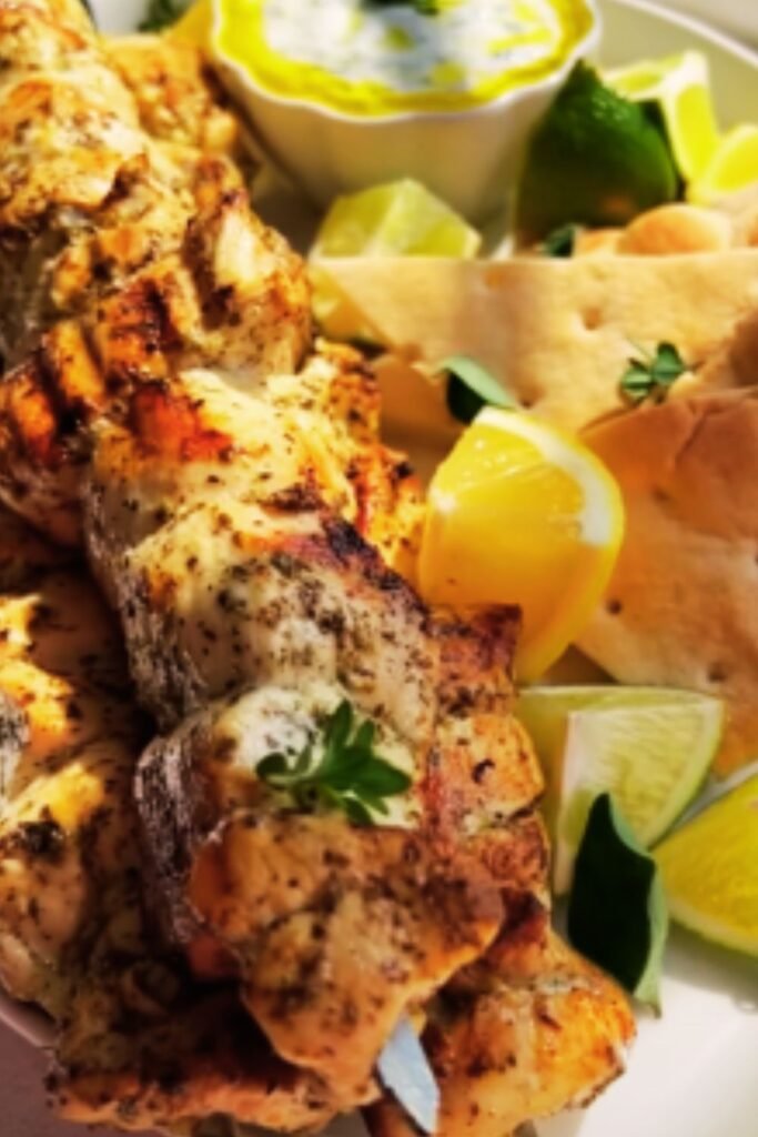Beautiful plated souvlaki with tzatziki, vegetables, and pita bread